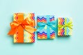 Wrapped Christmas or other holiday handmade present in paper with blue, green and orange ribbon on blue background. Present box, Royalty Free Stock Photo