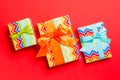 Wrapped Christmas or other holiday handmade present in paper with blue, green and orange ribbon on red background. Present box, Royalty Free Stock Photo