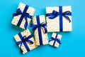 Wrapped Christmas or other holiday handmade present in paper with blue ribbon on blue background. Present box, decoration of gift Royalty Free Stock Photo