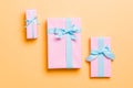 Wrapped Christmas or other holiday handmade present in paper with blue ribbon on orange background. Present box, decoration of Royalty Free Stock Photo