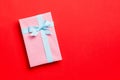 Wrapped Christmas or other holiday handmade present in paper with blue ribbon on red background. Present box, decoration of gift Royalty Free Stock Photo