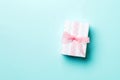 Wrapped Christmas or other holiday handmade present in paper with pink ribbon on blue background. Present box, decoration of gift Royalty Free Stock Photo