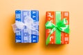 Wrapped Christmas or other holiday handmade present in paper with white and green ribbon on orange background. Present box, Royalty Free Stock Photo