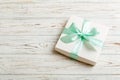 wrapped Christmas or other holiday handmade present in white paper with green ribbon on colored background. Present box Royalty Free Stock Photo