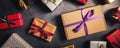 wrapped festive gifts on black stone background. top view banner