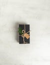 Wrapped gift black paper with fir tree branch and tag Royalty Free Stock Photo