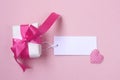 Wrapped gift box with pink bow, blank tag and heart Royalty Free Stock Photo