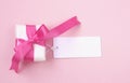Wrapped gift box with pink bow, blank tag Royalty Free Stock Photo