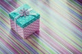 Wrapped gift box on stripy fabric background celebrations concep