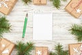 Wrapped gift boxes with handwritten notes near spruce branch on white wooden background, top view copy space. Secret Royalty Free Stock Photo