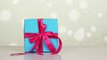 wrapped gift. close-up. blue gift box with pink ribbon. white bokeh background with a slight shimmer. Royalty Free Stock Photo