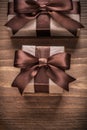 Wrapped gift containers with brown ribbons on vintage wooden boa Royalty Free Stock Photo