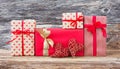 Wrapped gifts and two red hearts on wooden background. Toned, soft focus, vintage style