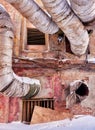 Wrapped in glassy pipe in the red brick wall of an abandoned old factory building Royalty Free Stock Photo