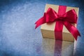 Wrapped golden present with red ribbon bow horizontal view