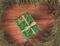 Wrapped in green paper gift box in green Christmas tree branches and cones. Toned image Royalty Free Stock Photo