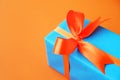 Wrapped present box on orange bright background. Holiday concept.