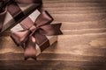 Wrapped present containers with brown ribbons on vintage wooden Royalty Free Stock Photo