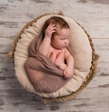 Wrapped sleepy baby with folded legs and hands on head Royalty Free Stock Photo