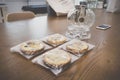 Wrapped sweet pumpkin and sweet potato pies and a glass kettle on wooden table