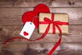 Wrapped vintage gift box with red ribbon bow and gift card on the wooden table
