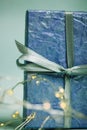 Wrapped in violet box with bow present among glowing LED garlands shining lights Royalty Free Stock Photo