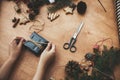 Wrapping rustic christmas gift. Hands wrapping christmas gift in stylish black paper and pine branches, cones, gingerbread cookies Royalty Free Stock Photo