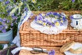 Wreath of cornflowers and chamomile on a wicker picnic suitcases in wheat field background