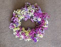 Wreath decoration on the house door of limonium sinuatum or statice salem flowers in blue, lilac, violet, pink, white colors on a Royalty Free Stock Photo