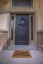 Wreath and doormat on the front door with sidelights and transom window