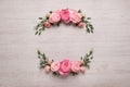 Wreath made of beautiful rose flowers and green leaves on white wooden background, flat lay. Space for text Royalty Free Stock Photo