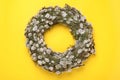 Wreath made of beautiful willow flowers on yellow background, top view. Space for text Royalty Free Stock Photo