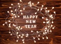 Wreath made of christmas lights on a wooden table. Happy New Year 2021 Royalty Free Stock Photo