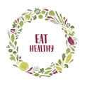 Wreath made of green plants, salad leaves, vegetables, herbs and Eat Healthy slogan inside. Decorative circular frame