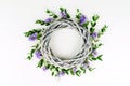 Wreath made of wicker circle, the branches of eucalyptus and purple flowers