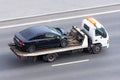 Wrecked car after an accident on a tow truck transported on a highway Royalty Free Stock Photo