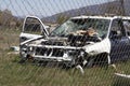 Wrecked car through a metal fence Royalty Free Stock Photo
