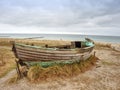 Wrecked wooden fisher boat. Broken abandoned boat in sand of sea bay. Royalty Free Stock Photo