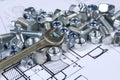 Wrench, bolts and nuts on background of engineering drawings. Royalty Free Stock Photo