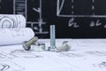 Wrench, bolts and nuts on background of engineering drawings.