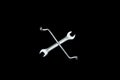Wrench in cross symbol and in black background