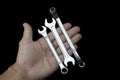 Wrench in hand and in black background