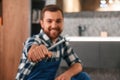 With wrench in hand. Plumber in blue uniform is at work in the bathroom Royalty Free Stock Photo