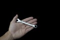 Wrench in handand and in black background Royalty Free Stock Photo