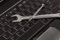 Wrench tool and screwdrivers over a laptop Royalty Free Stock Photo