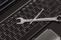 wrench tool and screwdrivers over a laptop Royalty Free Stock Photo