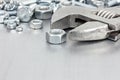 Wrench and various screws for hand work on grey scratched metal Royalty Free Stock Photo