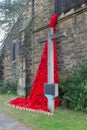 Weeping window poppy memorial commemorating WW1, with memorial cross. Royalty Free Stock Photo