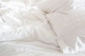 Wrinkle messy blanket and white pillow in bedroom after waking up in the morning, from sleeping in a long night, details of duvet Royalty Free Stock Photo