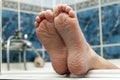 Wrinkled bare feet coming out from a bathtub. Young person getting a bath feet close-up indoor in bathroom interrior photo Royalty Free Stock Photo